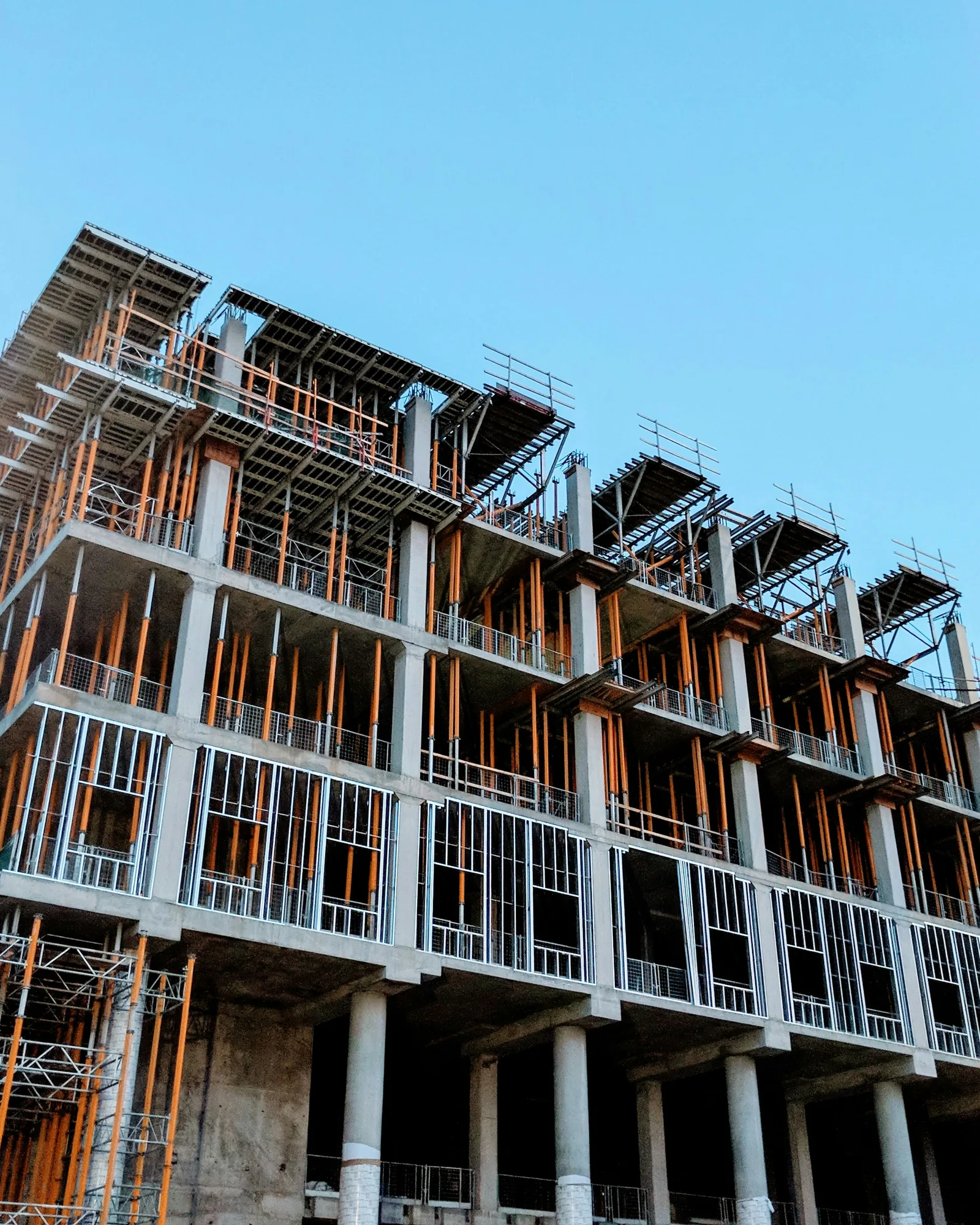 A multi-storey concrete frame under construction, floors poured and formwork still standing